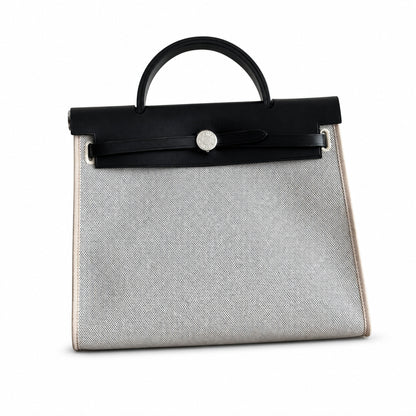 Hermers' popular herbag 31cm is designed to be inspired by saddle bags. The body of the bag is made of canvas and has outer seams. The shoulder straps and handbags are made of leather and look similar